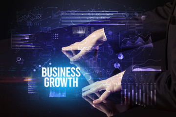 Businessman touching huge screen with BUSINESS GROWTH inscription, cyber business concept
