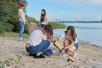 Group of students with teacher in nature doing cleaning of plastic garbage