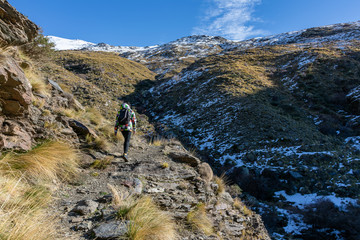 Young man walking on a path in Sierra Nevada, Spain.