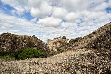 Fototapeta premium Amazing Meteora Monastery in Greece. Fantastic view at mountains and green forest against epic blue sky with clouds. UNESCO