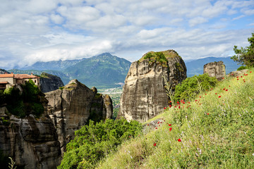 Amazing Meteora Monastery in Greece. Fantastic view at mountains and green forest against epic blue sky with clouds. UNESCO