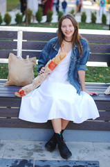 Beautiful girl eat baguette on the street