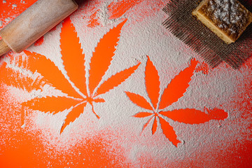 cooking cannabis food. Trail of cannabis leaf on white flour on Lush Lava color table. battledore....