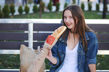 Beautiful girl eat baguette on the street