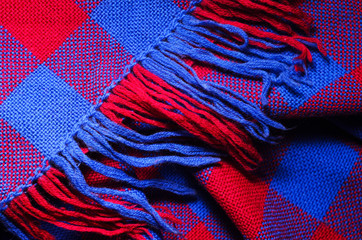 Blue and red checked scarf with fringe as background