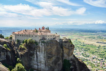 Obraz na płótnie Canvas Amazing Meteora Monastery in Greece. Fantastic view at mountains and green forest against epic blue sky with clouds. UNESCO
