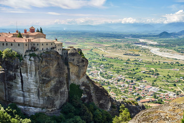 Fototapeta na wymiar Amazing Meteora Monastery in Greece. Fantastic view at mountains and green forest against epic blue sky with clouds. UNESCO