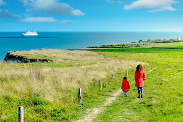 mom and her pretty little daughter on a walk on the coast in the north of France