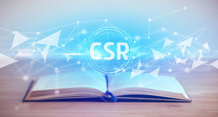 Open book with CSR abbreviation, modern technology concept