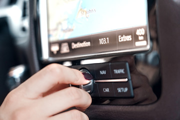 Mode of Transport. Electric car interior close-up woman rolling volume control button