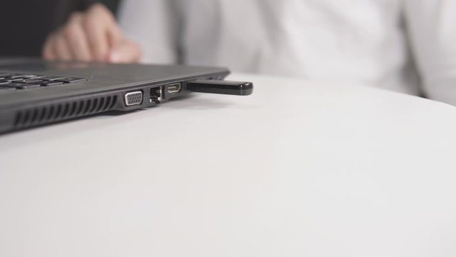Mann steckt USB Stick in den Laptop