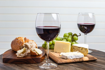 Party snacks and drinks, red wine, cheese, bread and grapes