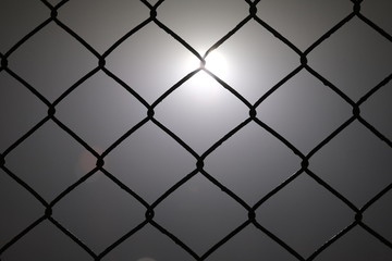 Metal wire in foggy night with light in background