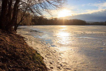 beautiful winter sunset with a view of the frozen lake