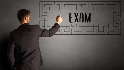 businessman drawing maze with EXAM inscription, business education concept