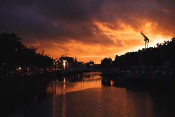 Dublin's cityscape during a colorful sunset with clouds and seagulls over Liffey river