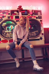 Fototapeta na wymiar Teenage girl sitting in club with neon light