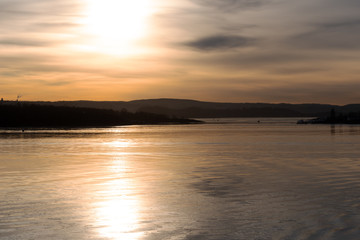 Obraz premium Blick auf eine Flusslandschaft in Norwegen in der Abenddämmerung im Gegenlicht mit Textfreiraum