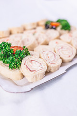 Ham roll ups on platter finger food buffet meal concept.