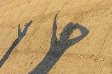 Sombra de mujeres felices bailando sobre pared de cemento