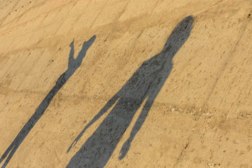 Sombras humanas sobre una pared de hormigón por la tarde