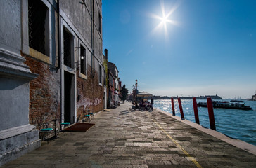 Walking on the bridges of the old city of Venice. Bright sun. The beauty of the ancient city. Italy.