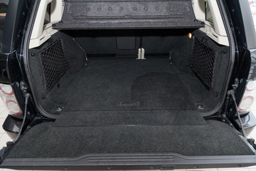 Open empty trunk of a car suv close-up before washing and vacuuming with a carpet floor mat of...