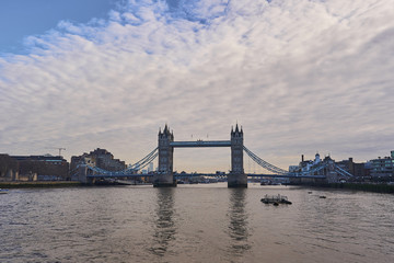 Obraz premium One of most popular attractions in London, capitol of Great Britain, the Tower bridge over the Thames river build in Victorian age of british imperium. Picture is taken in cloudy spring day.