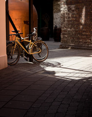 Yellow bicycle in city with dramatic shadows
