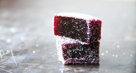 Blueberry pate de fruit (jelly, marmalade, fruit candy) covered with sugar on a dark background, back view