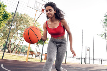 Basketball Player. Woman on court running dribbling concentrated bottom view close-up
