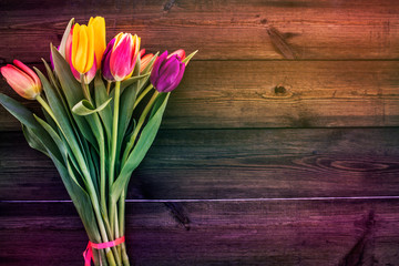 Bouquet of tulips on an iridescent wooden background