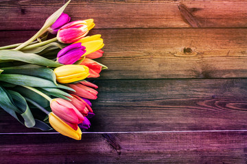 Bouquet of tulips on an iridescent wooden background, closeup