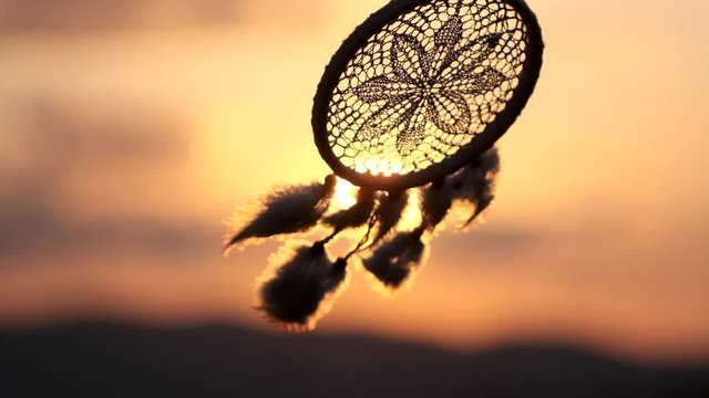 Dream catcher with white feathers flying in wind sun. Hunter of dreams against sunset. Summer time, textures, shaman, background, nature, craft, feathers, dreams, happiness, 120 slow-motion