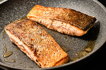 Cooking salmon filet on frying pan