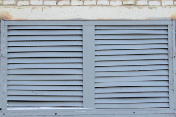 The iron grill on the wall in the form of blinds is painted gray.