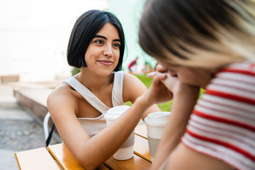 Loving lesbian couple having a date at coffee shop.
