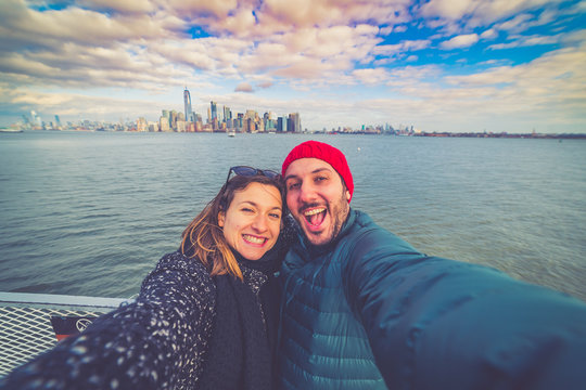 Tourist friends couple taking selfie picture on Ellis Island with manhattan view, NYC, USA