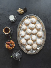 Festive Ramadan sweets are served with tea on the black table. Egyptian cookies 