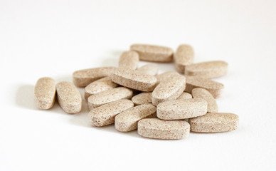 Obraz na płótnie Canvas Daily vitamins on the white background. Light brown pills isolated on white. Multivitamins.