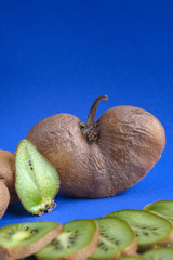 Big ugly vegetable organic kiwi on a green background. Sweet fruit slices. Ugly food concept.