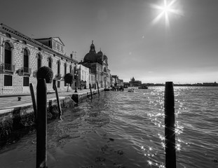 Everyday life of a gondolier. Walking on the bridges of the old city of Venice. Bright sun. The beauty of the ancient city. Italy. Black and white.