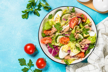 Tuna salad with green leaves, eggs and vegetables.