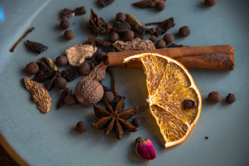 Dried oriental spices for making drinks on a home ceramic plate. Home kitchen.