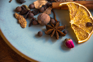 Dried oriental spices for making drinks on a home ceramic plate. Home kitchen.