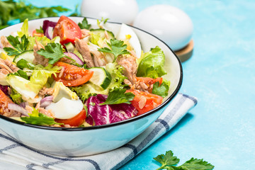 Tuna salad with green leaves, eggs and vegetables.