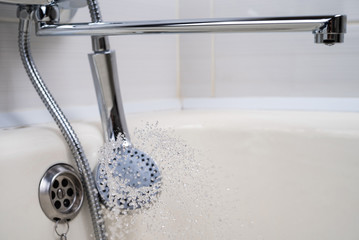 Jets of water flow from the shower head. Selective focus.