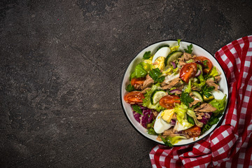 Tuna salad with green leaves, eggs and vegetables.