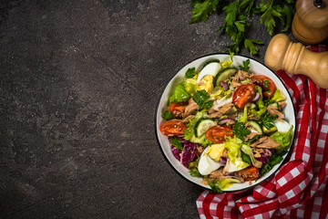Tuna salad with green leaves, eggs and vegetables.