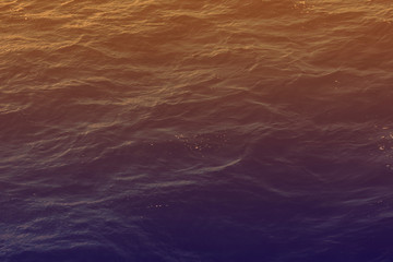 Creative layout made of Mediterranean sea surface with gradient violet and orange colors. Copy space aquatic background